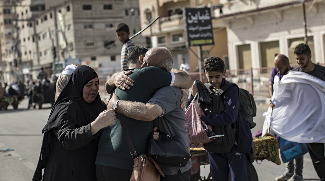 Παλαιστίνιοι αγκαλιάζονται, ενώ απομακρύνονται από τη βόρεια Γάζα