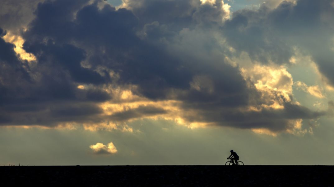 Ένας ποδηλάτης υπό βαριά συννεφιά