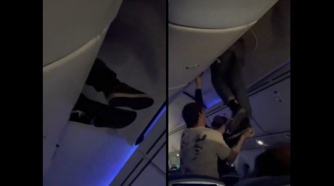 εσωτερικο αεροπλανου, επιβατες βοηθουν ανδρα να ξεκολλησει απο ντουλάπι χειραποσκευών