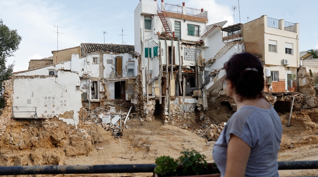 γυναικα κοιταζει κατεστραμμένο σπίτι, πλημμυρα