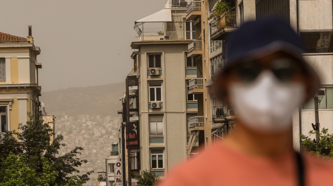 ανθρωπος με μασκα, νεφος, πολυκατοικιες