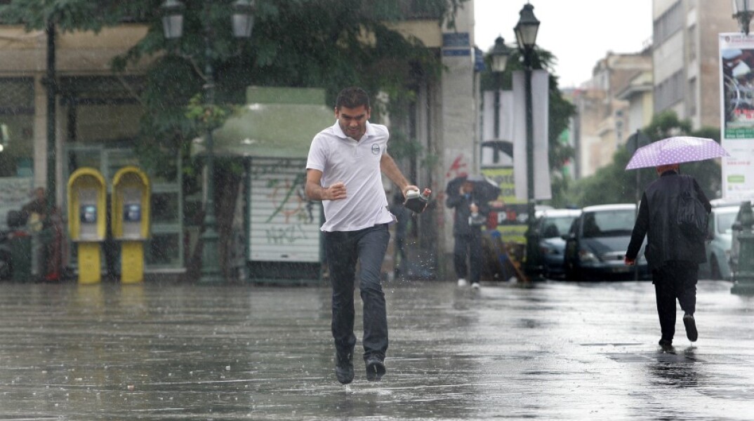 Άντρας τρέχει να αποφύγει τη βριχή στιο κέντρο της Αθήνας©ΑΠΕ-ΑΛΕΞΑΝΔΡΟΣ ΒΛΑΧΟΣ
