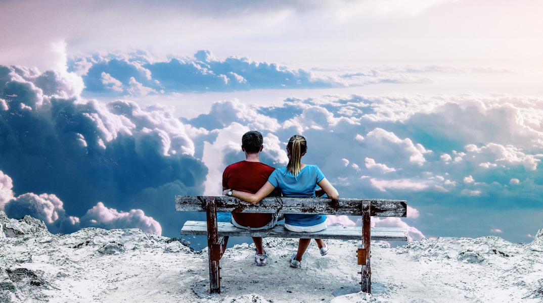 Άνθρωποι που κάθονται σε παγκάκι και βλέπουν τα σύννεφα