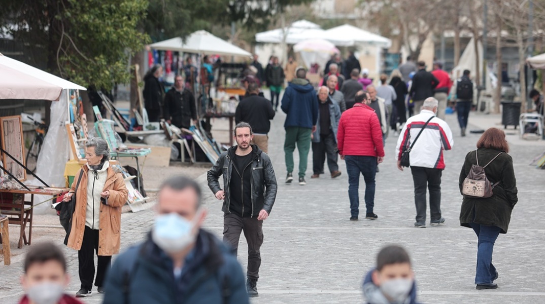 Πολίτες περπατούν σε δρόμο της Αθήνας μετά την εκ νέου κατάργηση της υποχρεωτικότητας να φοράμε μάσκα σε ανοιχτούς χώρους