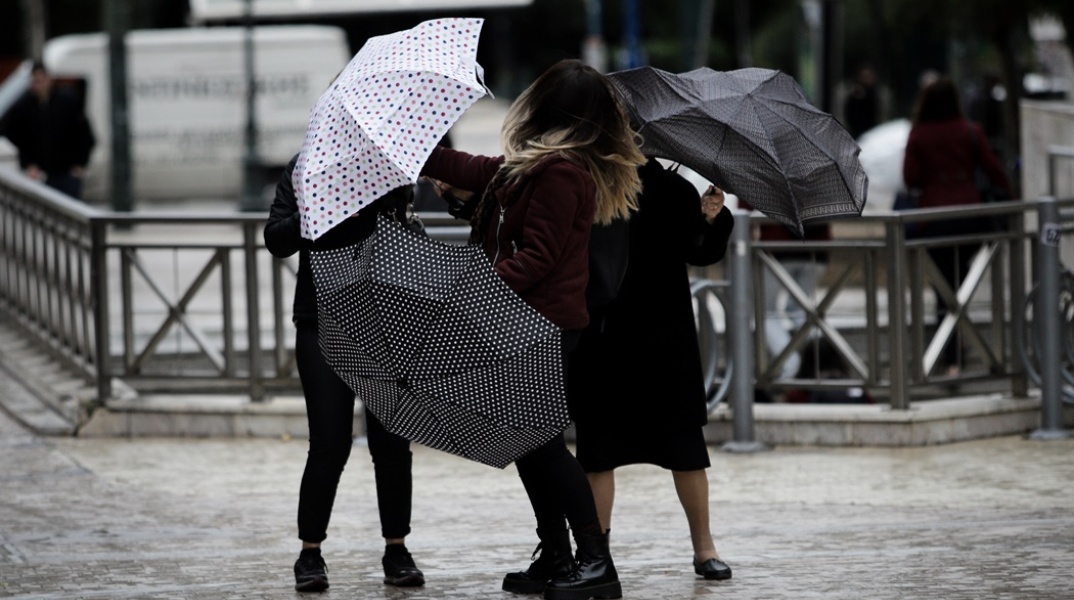 Βροχή στην Αθήνα: Πολίτες ανοίγουν την ομπρέλα τους βγαίνοντας από το μετρό