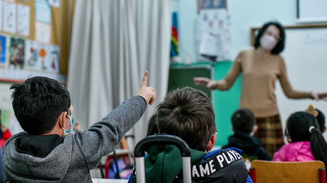 Δασκάλα μέσα σε τάξη εν ώρα μαθήματος - Οι μικροί μαθητές σηκώνουν το χέρι τους