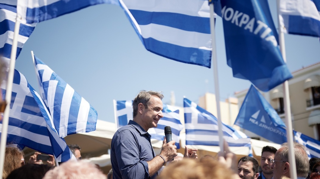 Ο Κυριάκος Μητσοτάκης μαζί με φίλους της ΝΔ που κρατούν σημαίες της Ελλάδας και του κόμματος