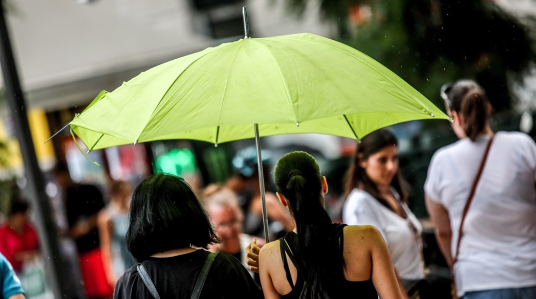 Γυναίκα κρατά ομπρέλα για τη βροχή 