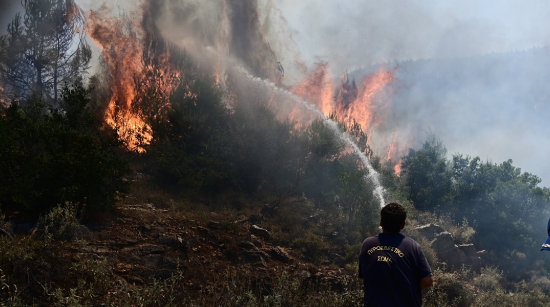 Πυροσβέστης επιχειρεί για την κατάσβεση της φωτιάς στα Δερβενοχώρια