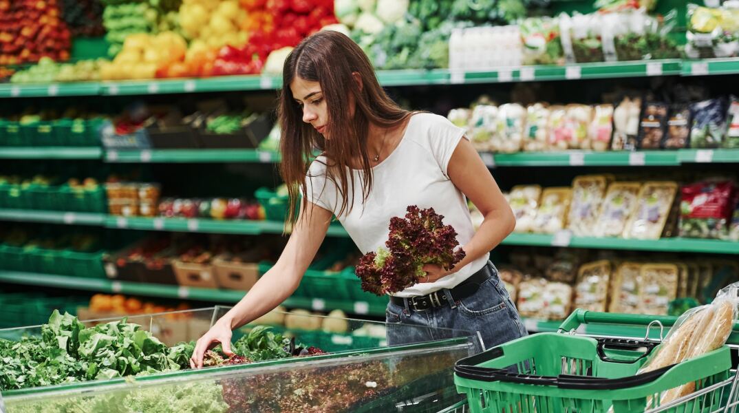 Γυναίκα ψωνίζει λαχανικά και φρούτα στο σούπερ μάρκετ