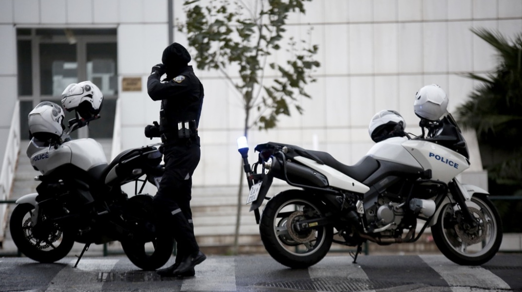 Αστυνομίκος δίπλα σε μηχανή της ΕΛ.ΑΣ. έξω από το κτίριο του Εφετείου Αθηνών