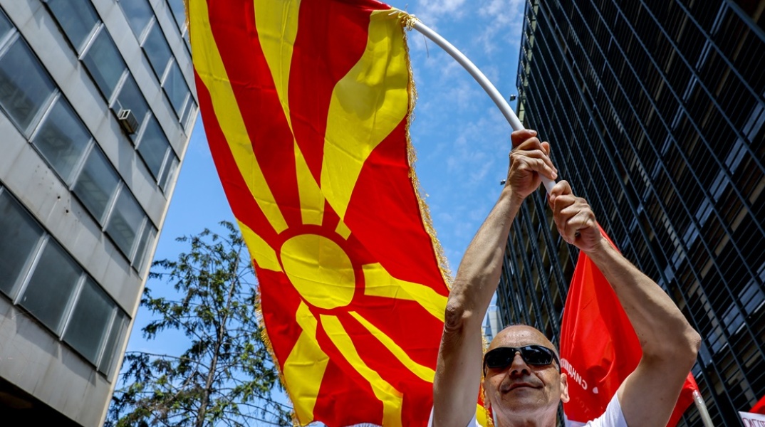 Άτομο κρατά τη σημαία της Βόρειας Μακεδονιας