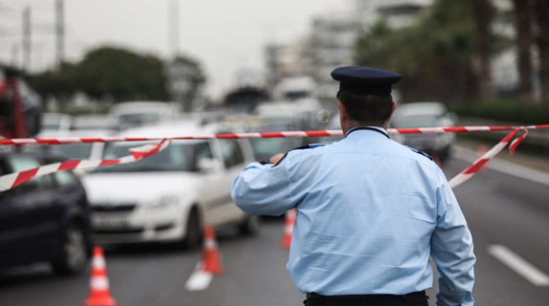 Τροχονόμος με κορδέλα της αστυνομίας έχει αποκλείσει σημείο και ρυθμίζει την κυκλοφορία