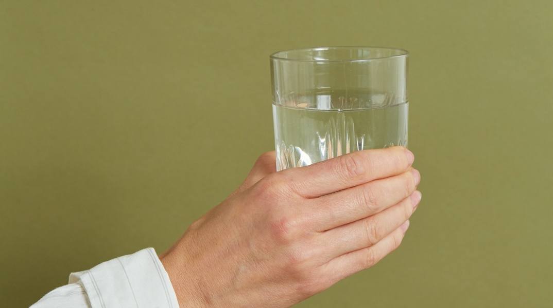 Χέρι που κρατά ποτήρι με νερό