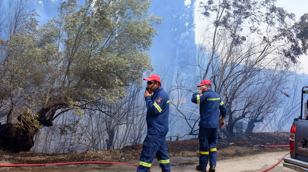 Πυροσβέστες επιχειρούν για την κάτασβεση φωτιάς φορώντας μάσκες