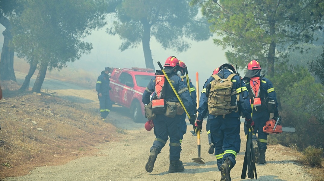 Πυροσβέστες με εξοπλισμό κατά τη διάρκεια κατάσβεσης φωτιάς