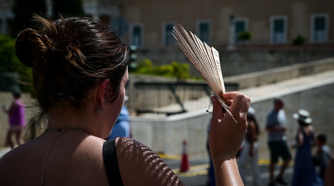 Γυναίκα με βεντάλια στα χέρια εν μέσω καύσωνα