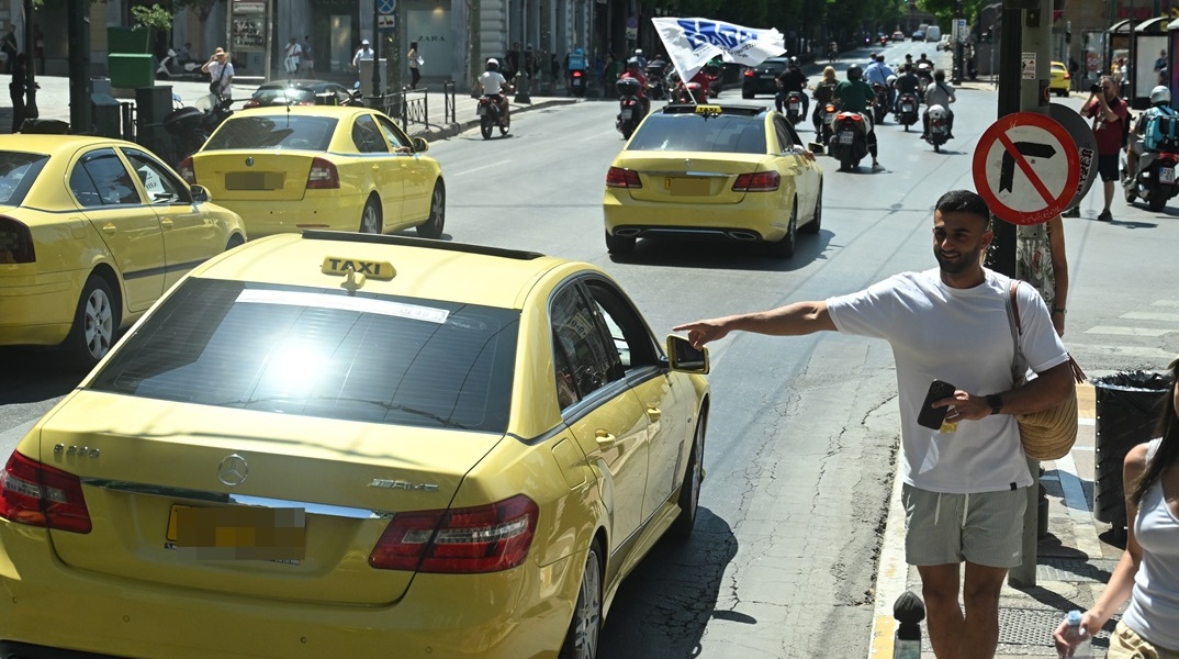 Ταξί και άτομο που σηκώνει το χέρι του για να καλέσει ταξί