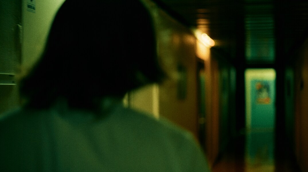 Γυναίκα σε σκοτεινό διάδρομο - Εικόνα που παραπέμπει σε κακοποίηση και ενδοοικογενειακή βία