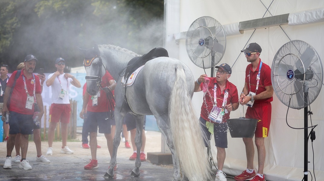 Αθλητές και διοργανωτές δροσίζουν άλογο στο περιθώριο των Ολυμπιακών Αγώνων 2024