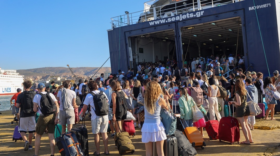 Επιβάτες αναμένουν να επιβιβαστούν στο πλοίο για τις καλοκαιρινές τους διακοπές