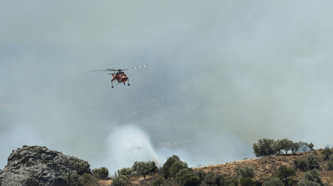 Καπνοί και πυροσβεστικό ελικόπτερο που επιχειρεί στη φωτιά στο Ρέθυμνο