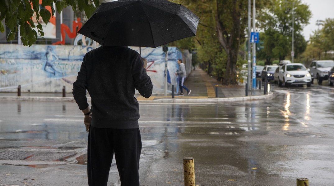 Άτομο με ομπρέλα εν μέσω βροχής στη Θεσσαλονίκη