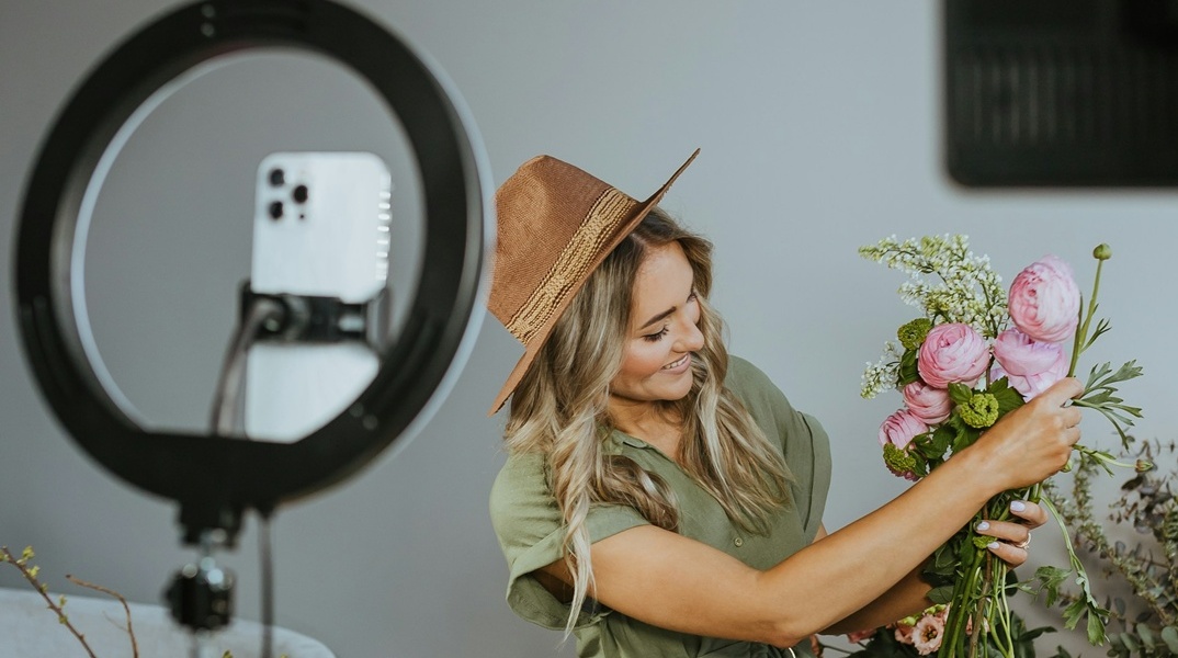 Κοπέλα δείχνει φυτά μπροστά από ring light