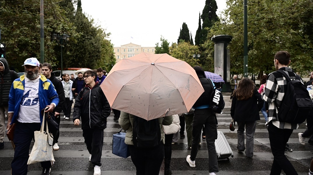 Άτομα με ομπρέλες σε βροχή