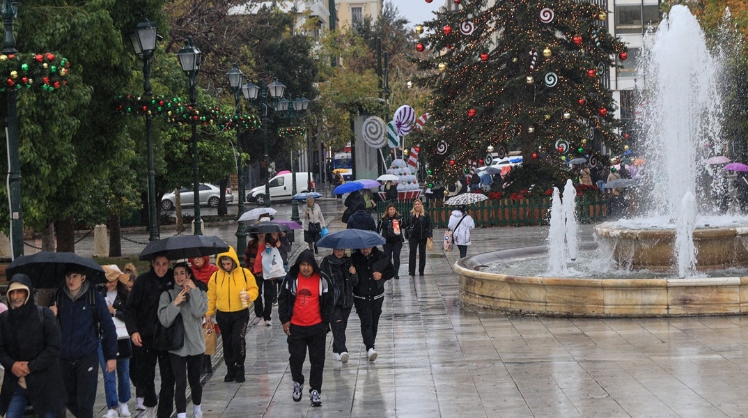 Πολίτες με ομπρέλες εν μέσω βροχής στο Σύνταγμα