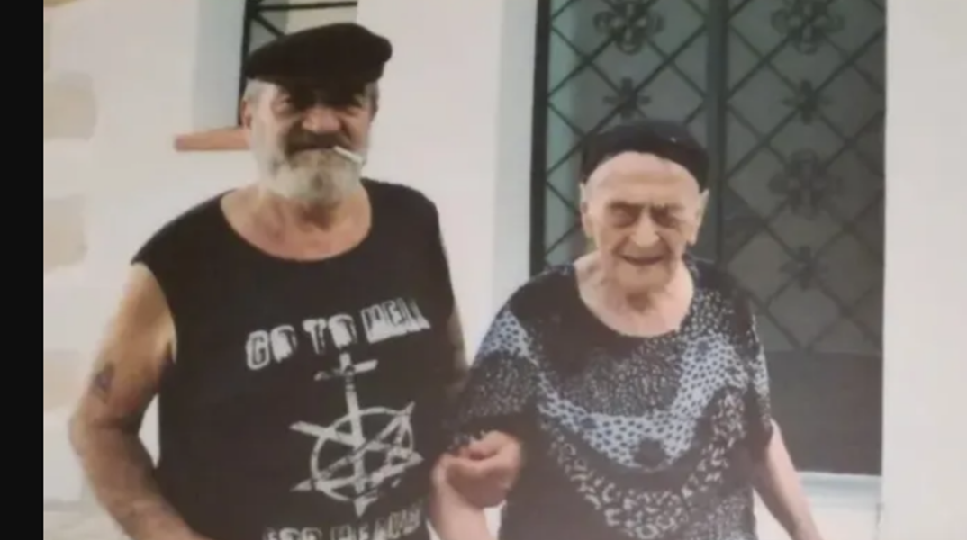 Η γηραιότερη γυναίκα στην Ελλάδα σε παλαιότερη φωτογραφία υποβασταζόμενη από έναν άνδρα με τσιγάρο στα χείλη