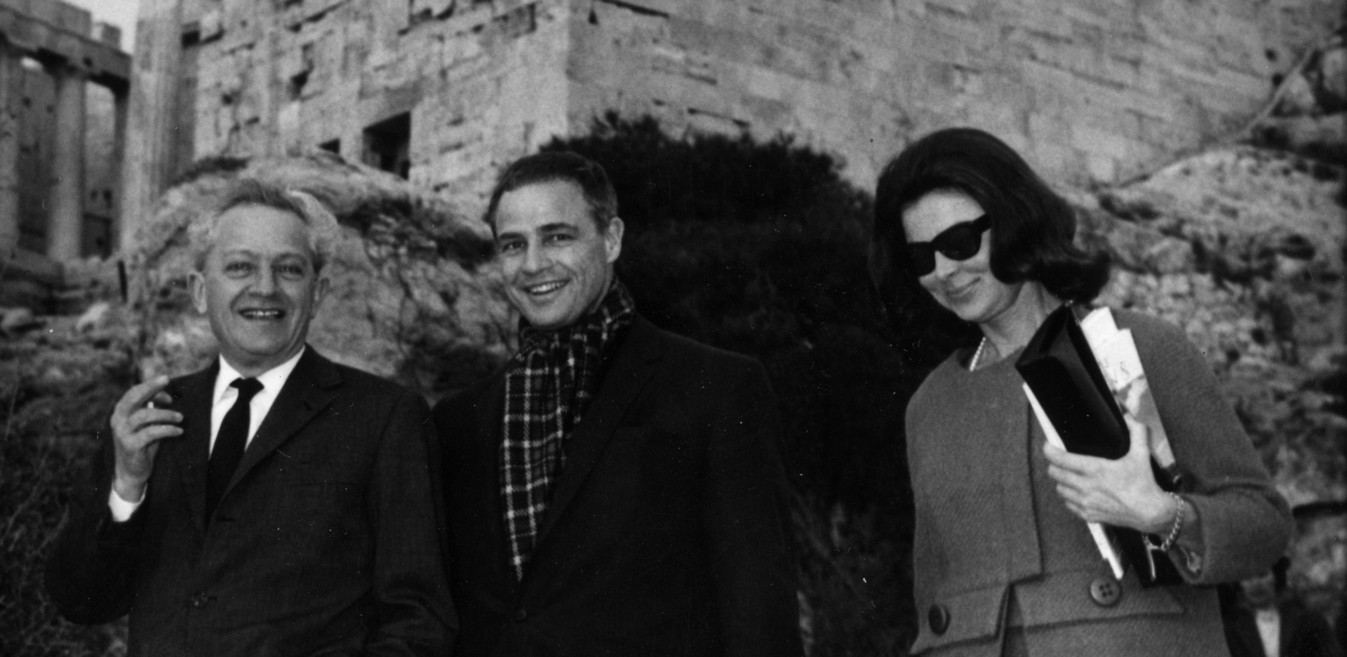 Ο Marlon Brando στην Αθήνα το 1965: Ο αμερικανός σταρ του κινηματογράφου επισκέπτεται την Ακρόπολη με τον εξόριστο τότε σκηνοθέτη του Hollywood Jules Dassin. Πίσω τους τα Προπύλαια της Ακρόπολης / (Photo by Keystone/Getty Images)