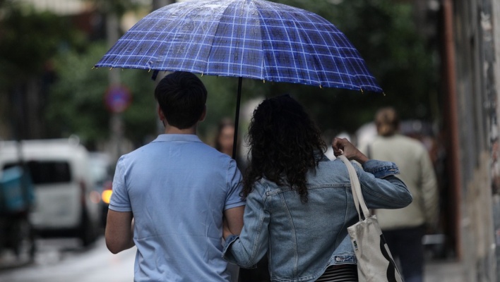 Πολίτες με ομπρέλα προστατεύονται από τη βροχόπτωση