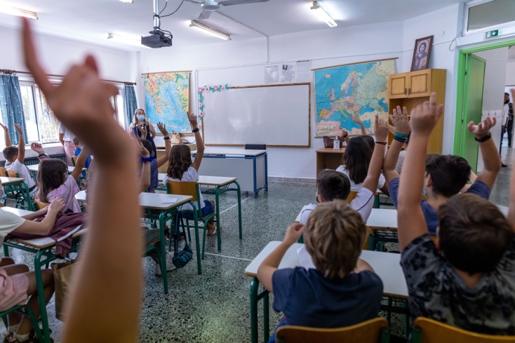 Παιδιά με υψωμένα τα χέρια τους για να πουν μάθημα σε σχολική αίθουσα